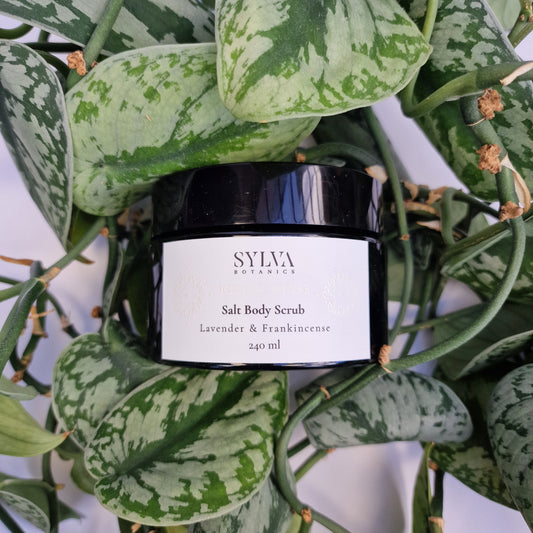 Sylva Botanics salt body scrub packaging surrounded by green leaves